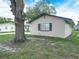 The house has a brick exterior, a large tree, and a blue shutter on the windows at 228 Kilmer Ln, Winter Haven, FL 33884