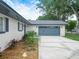 Attached two-car garage with a concrete driveway and a meticulously maintained landscape bed at 228 Kilmer Ln, Winter Haven, FL 33884