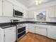 Bright kitchen featuring white cabinets, stainless steel appliances, and laminate countertops at 228 Kilmer Ln, Winter Haven, FL 33884