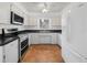 Bright kitchen featuring white cabinets, stainless steel appliances, and laminate countertops at 228 Kilmer Ln, Winter Haven, FL 33884