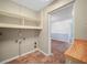 Laundry room with tile floor, open shelving and view into a recreational room at 228 Kilmer Ln, Winter Haven, FL 33884