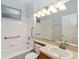 Full bathroom includes a shower-tub combo, white tile surround, and a large mirror at 2280 Yorville Ct, Ocoee, FL 34761