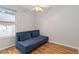 Small room with hardwood floors features a futon and natural light from a window at 2280 Yorville Ct, Ocoee, FL 34761