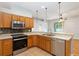 Bright kitchen featuring stainless steel appliances, wood cabinets, and tile flooring at 2280 Yorville Ct, Ocoee, FL 34761