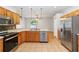 Open kitchen design boasts stainless steel appliances, wood cabinets, and tile floors at 2280 Yorville Ct, Ocoee, FL 34761