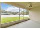 Enclosed lanai has a screened in view of the spacious green backyard on a sunny day at 2280 Yorville Ct, Ocoee, FL 34761