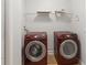 This laundry room features a front load washer, dryer, and wire shelving for maximum convenience at 2280 Yorville Ct, Ocoee, FL 34761