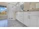 Bright bathroom with a glass shower, double sink vanity, granite counters, and attractive gray tile flooring at 2406 Placid Way, Kissimmee, FL 34758