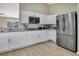 Modern kitchen features stainless steel appliances, granite counters, and white shaker style cabinetry at 2406 Placid Way, Kissimmee, FL 34758