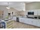 Bright eat-in kitchen features granite counters, stainless steel appliances, and light woodgrain tile floors at 2406 Placid Way, Kissimmee, FL 34758