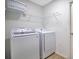 Functional laundry room featuring a washer and dryer with overhead shelving at 2406 Placid Way, Kissimmee, FL 34758