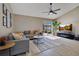 Bright living room with a plush grey sofa and sliding doors leading to the patio and pool at 2406 Placid Way, Kissimmee, FL 34758