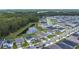Expansive aerial view of a neighborhood showcasing well-maintained homes near a pond and a lush green forest at 2836 Sanctuary Dr, Clermont, FL 34714