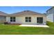 View of a backyard with green lawn, patio and sliding glass door at 2836 Sanctuary Dr, Clermont, FL 34714