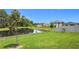 Backyard view of a pond, green lawn, and homes at 2836 Sanctuary Dr, Clermont, FL 34714