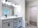 Bathroom featuring a double sink vanity with gray cabinets, black hardware, and a large mirror at 2836 Sanctuary Dr, Clermont, FL 34714