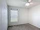 Bedroom featuring a ceiling fan, a large window, and neutral-colored walls and carpeting at 2836 Sanctuary Dr, Clermont, FL 34714