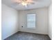 Bedroom featuring a ceiling fan, a large window, and neutral-colored walls and carpeting at 2836 Sanctuary Dr, Clermont, FL 34714