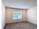 Bedroom with neutral colored carpeting and a large window with view to the exterior at 2836 Sanctuary Dr, Clermont, FL 34714