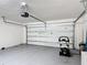 View of a clean garage with epoxy flooring, an automatic door, and good ceiling height at 2836 Sanctuary Dr, Clermont, FL 34714