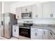Kitchen showcasing stainless steel appliances, including a refrigerator, microwave, and range at 2836 Sanctuary Dr, Clermont, FL 34714
