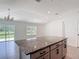 Kitchen with large island featuring granite countertops and dark gray cabinets at 2836 Sanctuary Dr, Clermont, FL 34714