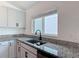 Close up shot of a kitchen sink with granite countertops and white cabinets at 2836 Sanctuary Dr, Clermont, FL 34714