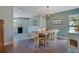 Inviting dining room featuring a wooden table, elegant chandelier, and view into the bright kitchen at 2901 Autumnwood Trl, Apopka, FL 32703
