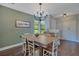 Inviting dining room featuring a wooden table, elegant chandelier, with views of the front yard at 2901 Autumnwood Trl, Apopka, FL 32703