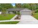 Charming single-story home with stone accents, manicured lawn, and two-car garage on a sunny day at 2901 Autumnwood Trl, Apopka, FL 32703