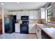 Bright kitchen featuring white cabinetry, black appliances, and butcher block countertops at 2901 Autumnwood Trl, Apopka, FL 32703