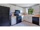Well-lit kitchen features black appliances, white cabinets, and a window view at 2901 Autumnwood Trl, Apopka, FL 32703