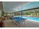 A spacious screened-in pool area featuring a ping pong table and seating for entertaining at 2901 Autumnwood Trl, Apopka, FL 32703