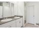 Bathroom featuring double sinks, granite counters, and a doorway to a walk-in closet at 3210 Viceroy Ct, Poinciana, FL 34759