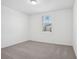 A carpeted bedroom features a window with blinds, showcasing a bright and airy space at 3210 Viceroy Ct, Poinciana, FL 34759