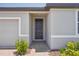 Close-up of a stylish black front door with brick walkway, and manicured front yard at 3210 Viceroy Ct, Poinciana, FL 34759