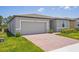 Single-story home with brick paver driveway, and attractive landscaping at 3210 Viceroy Ct, Poinciana, FL 34759
