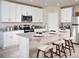 Modern kitchen features white cabinets, stainless steel appliances, and a granite island with seating at 3210 Viceroy Ct, Poinciana, FL 34759