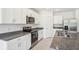 Well-lit kitchen featuring white cabinets, stainless steel appliances, and gray countertops at 3210 Viceroy Ct, Poinciana, FL 34759