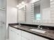 Bathroom featuring double sinks, granite countertops, decorative mirrors and a glass shower at 344 Buenaventura Blvd, Kissimmee, FL 34743