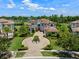 Aerial view of luxury home showcasing landscaping, tile roof, circular driveway, and lake views at 4071 Isabella Cir, Windermere, FL 34786