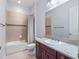 Bathroom with granite counters, a large mirror, and combination shower and tub at 4071 Isabella Cir, Windermere, FL 34786