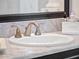 Close-up of bathroom sink and vanity with granite counters, a white sink and brushed gold faucet at 4071 Isabella Cir, Windermere, FL 34786