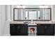 Bathroom vanity with double sinks, dark cabinets, marble counters, and a stool at 4071 Isabella Cir, Windermere, FL 34786