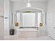Bright bathroom featuring a garden tub, decorative columns, and a large window at 4071 Isabella Cir, Windermere, FL 34786