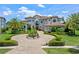 Beautiful home with manicured landscaping, mature palm trees, and a circular brick driveway at 4071 Isabella Cir, Windermere, FL 34786