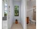 Hallway leading to a bathroom with a plant sitting beneath a window at 4071 Isabella Cir, Windermere, FL 34786