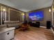 Spacious living room with gray leather seating, wood floors, and home theater at 4071 Isabella Cir, Windermere, FL 34786