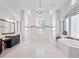 Expansive bathroom featuring a chandelier, double shower, soaking tub, and marble accents at 4071 Isabella Cir, Windermere, FL 34786