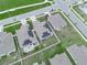 An aerial view showcases a residential neighborhood featuring modern homes with solar panels and well-maintained lawns at 440 Patricia Alford Dr, Haines City, FL 33844